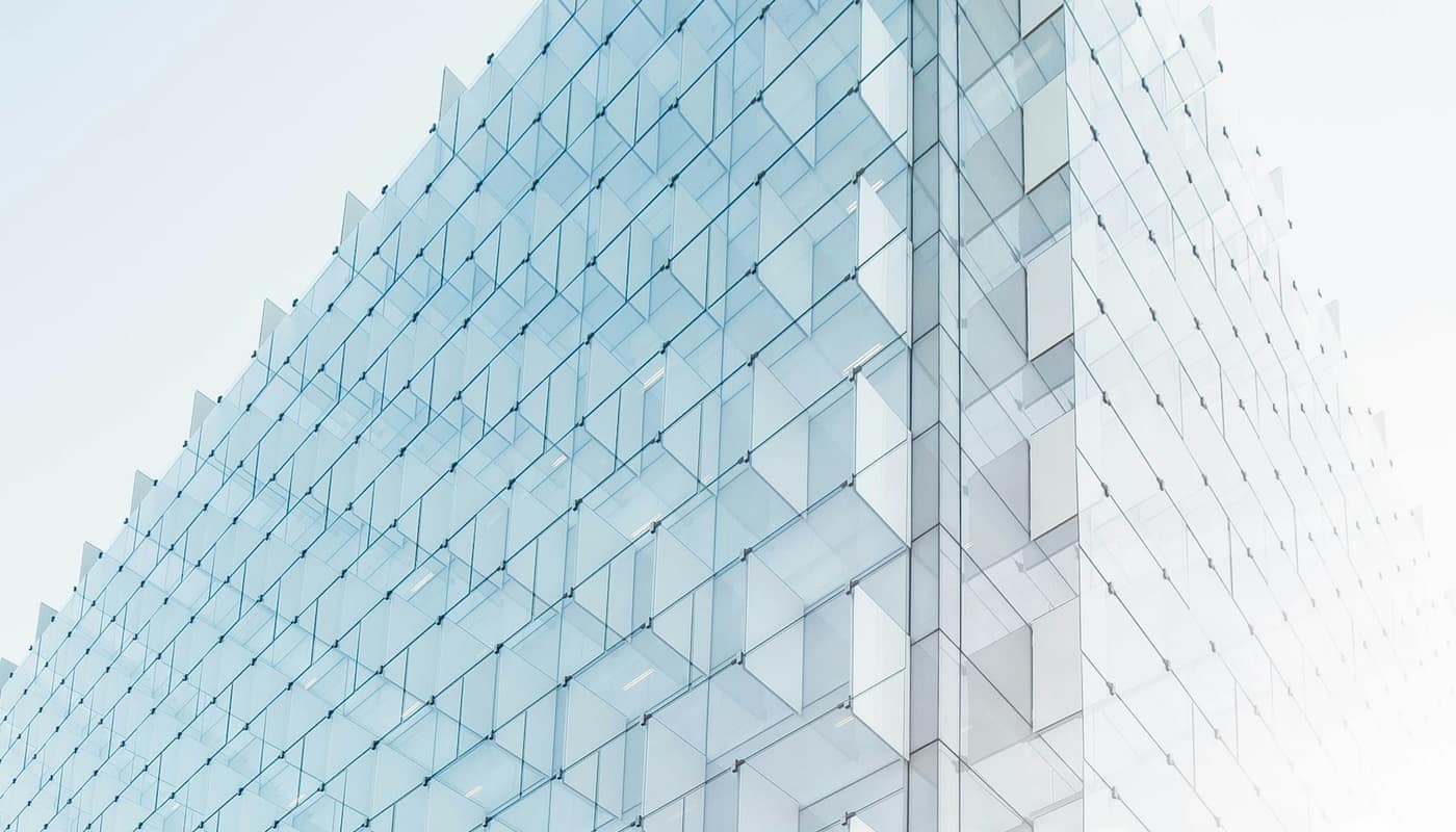 The pale glass facade of a modern building, shot looking up