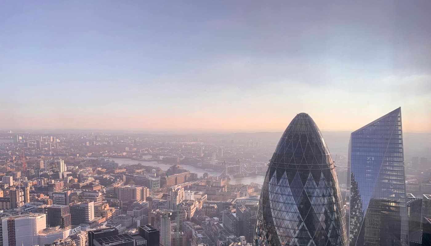 An aerial view of the City of London skyline at dusk with the Gherkin in the foreground