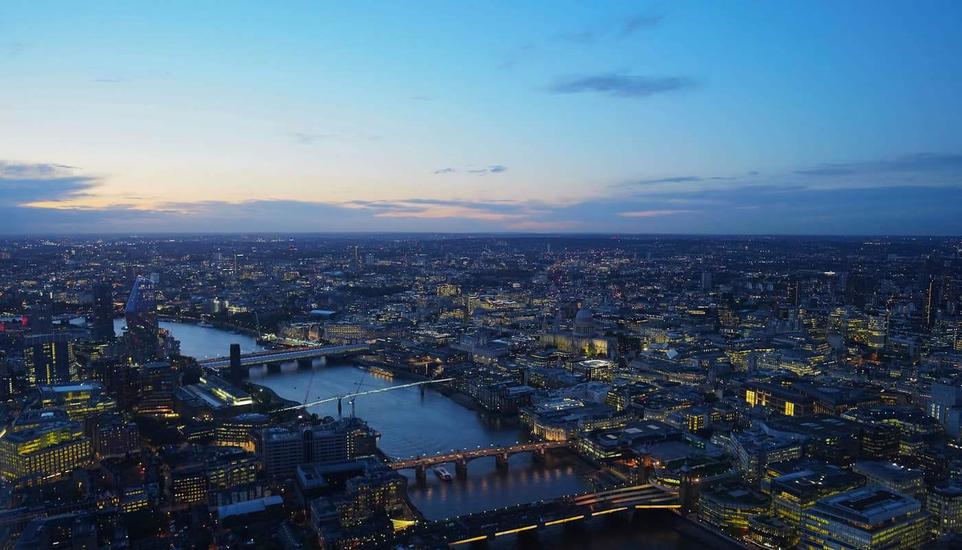 An aerial view of the River Thames and the City of London lit at dusk