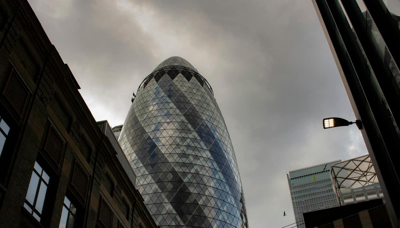 Glass and stone buildings in the City of London with the Gherkin tower on the right