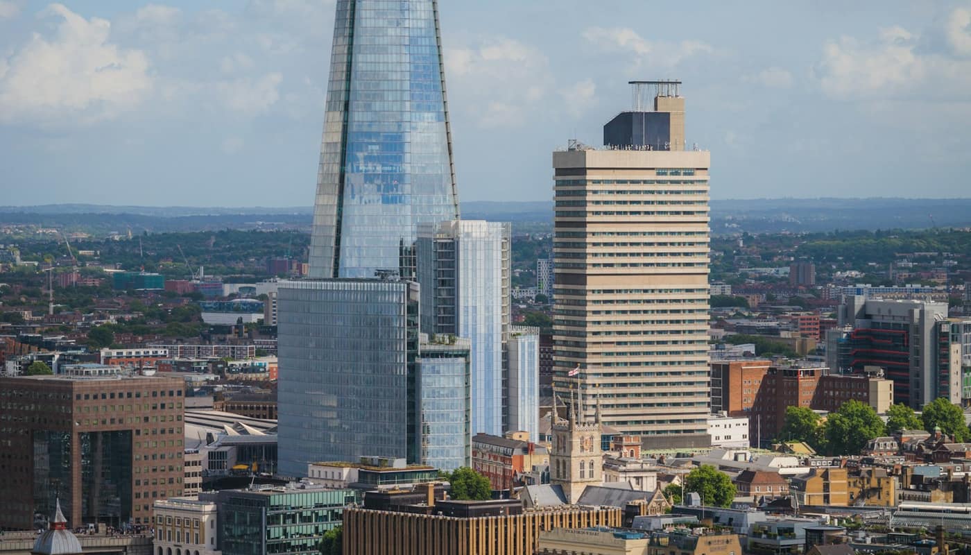 The Shard and other towers rising above city rooftops under a cloudy sky